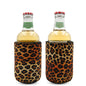 Two glass beverage bottles with red caps wrapped in leopard print insulated stubby coolers.
